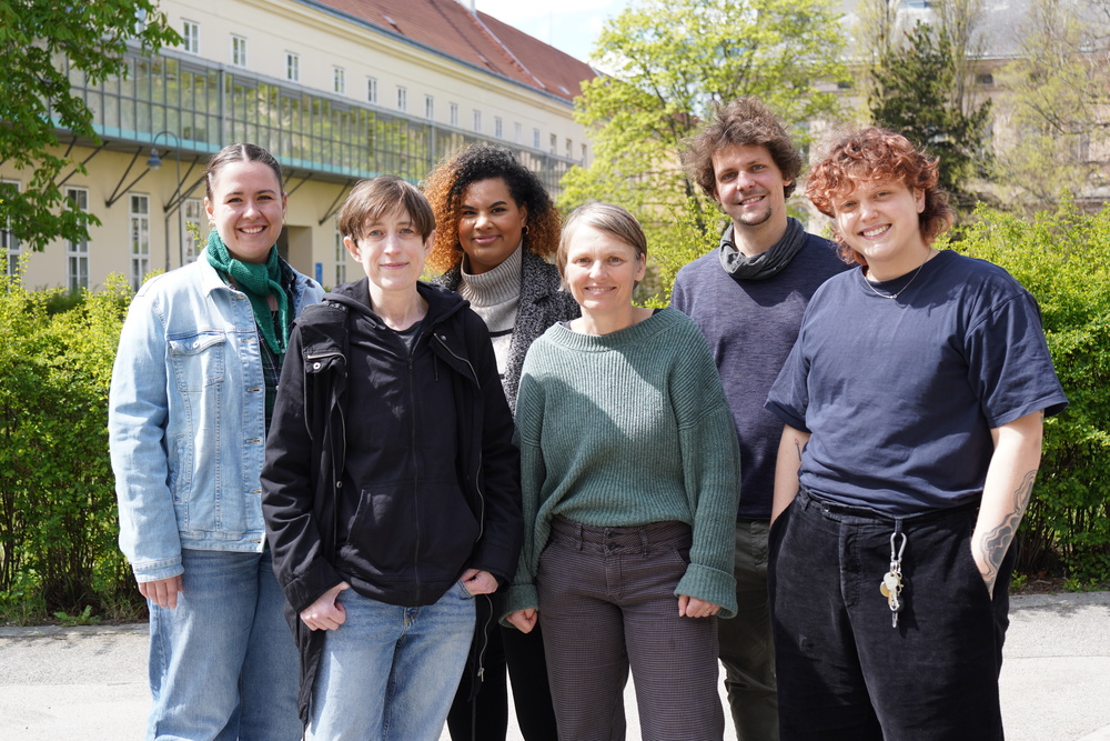 Alle Teammitglieder des ASH Forum stehen eng zusammen. im hintergrund sieht man ein Gebäude des Alten AKH bzw. Bäume und Grün.